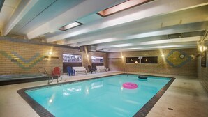 An indoor swimming pool with a tiled floor, a few lounge chairs, and a clock on the wall. - 2bd TMC 207 (Frisco)