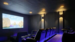 A home theater with a large screen, reclining seats, and ambient lighting. - Timeless-Texas-Inn • Heated Pool Oasis • LUX Vibe (Round Rock)