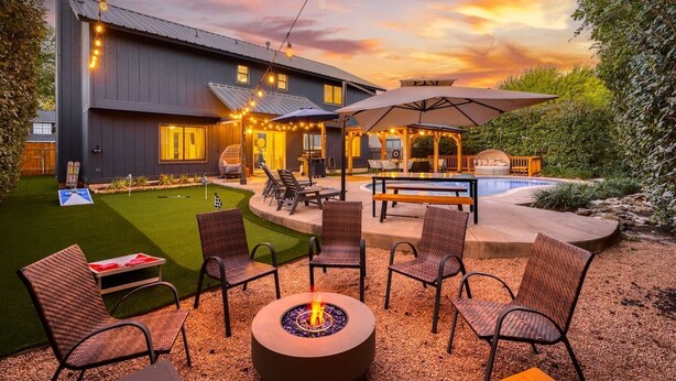 A modern outdoor patio with a fire pit, seating, and a pool area. - Timeless-Texas-Inn • Heated Pool Oasis • LUX Vibe (Round Rock)
