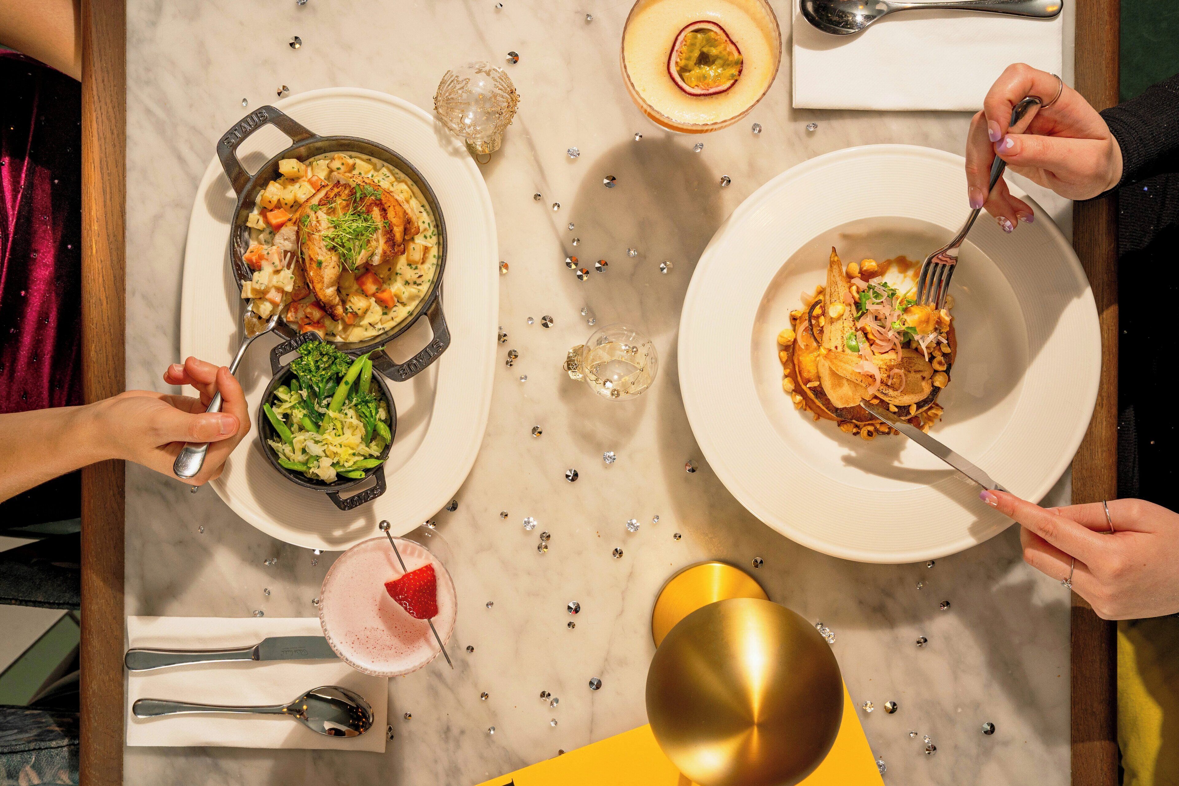 A dining table with various dishes, utensils, and a drink.
