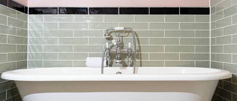 Una bañera con grifo cromado y una toalla blanca.