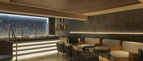A modern lounge area with a staircase, seating, and a view of the city.