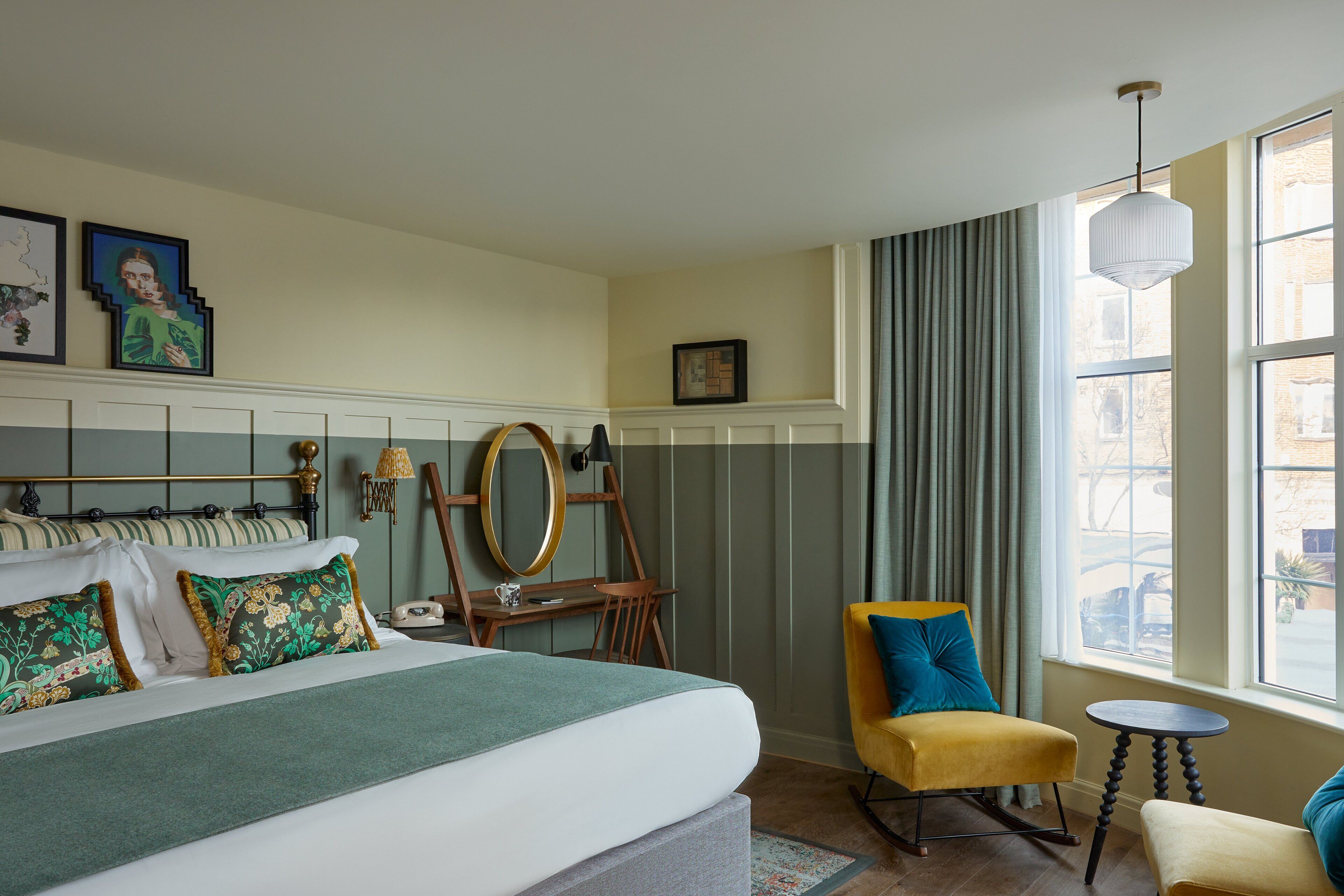 Un dormitorio ordenado con cama, escritorio, silla y ventana con cortinas.