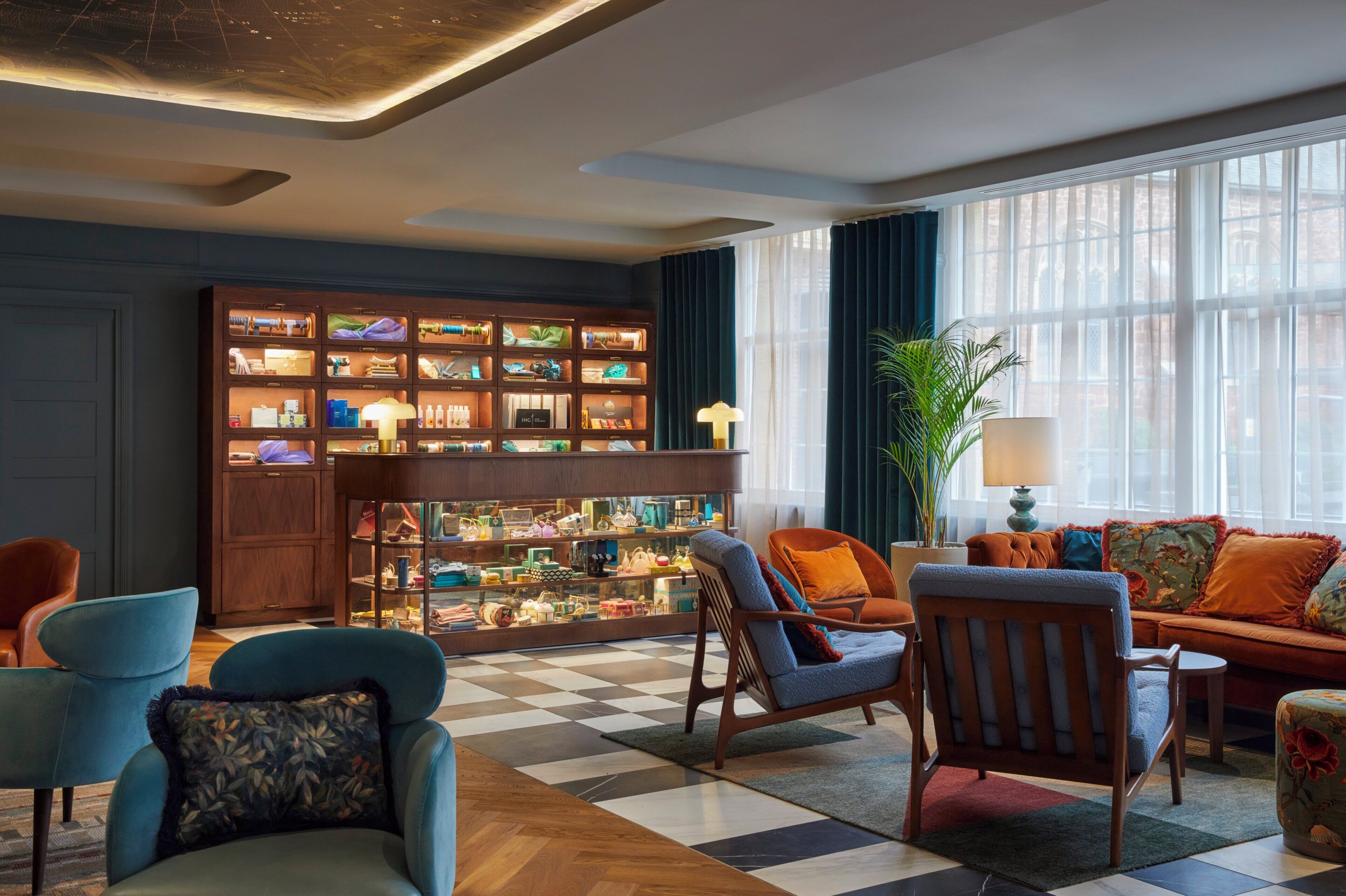 A well-lit living room with a checkered floor, a large wooden display case filled with items, and comfortable seating including a sofa and chairs.