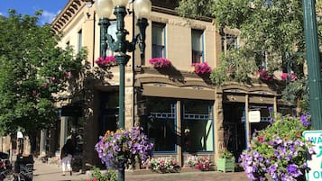 A historic building with a prominent clock tower, large windows, and flower boxes on the facade.