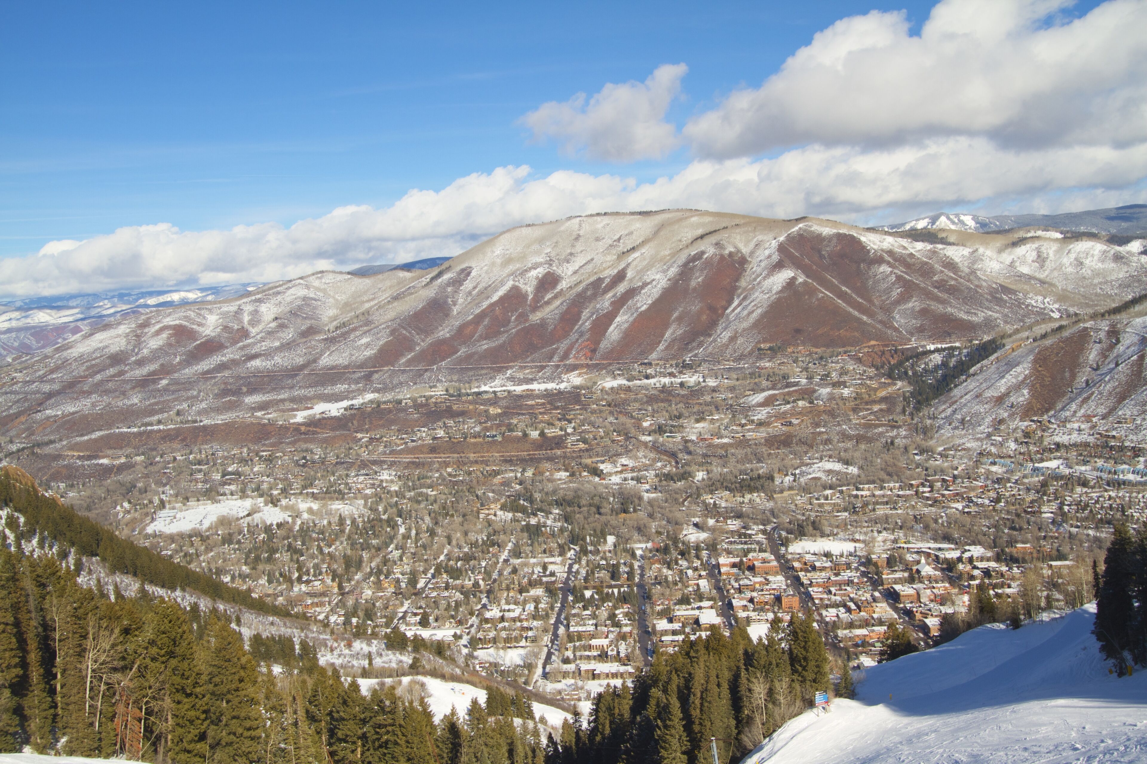 A town nestled in a valley with snow-covered mountains in the background.