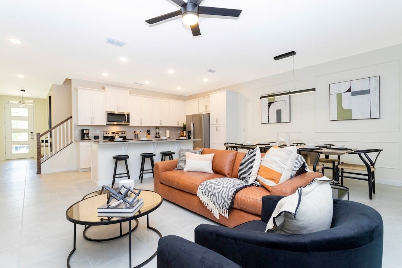 A modern living room with a sofa, coffee table, and a dining area with a table and chairs.