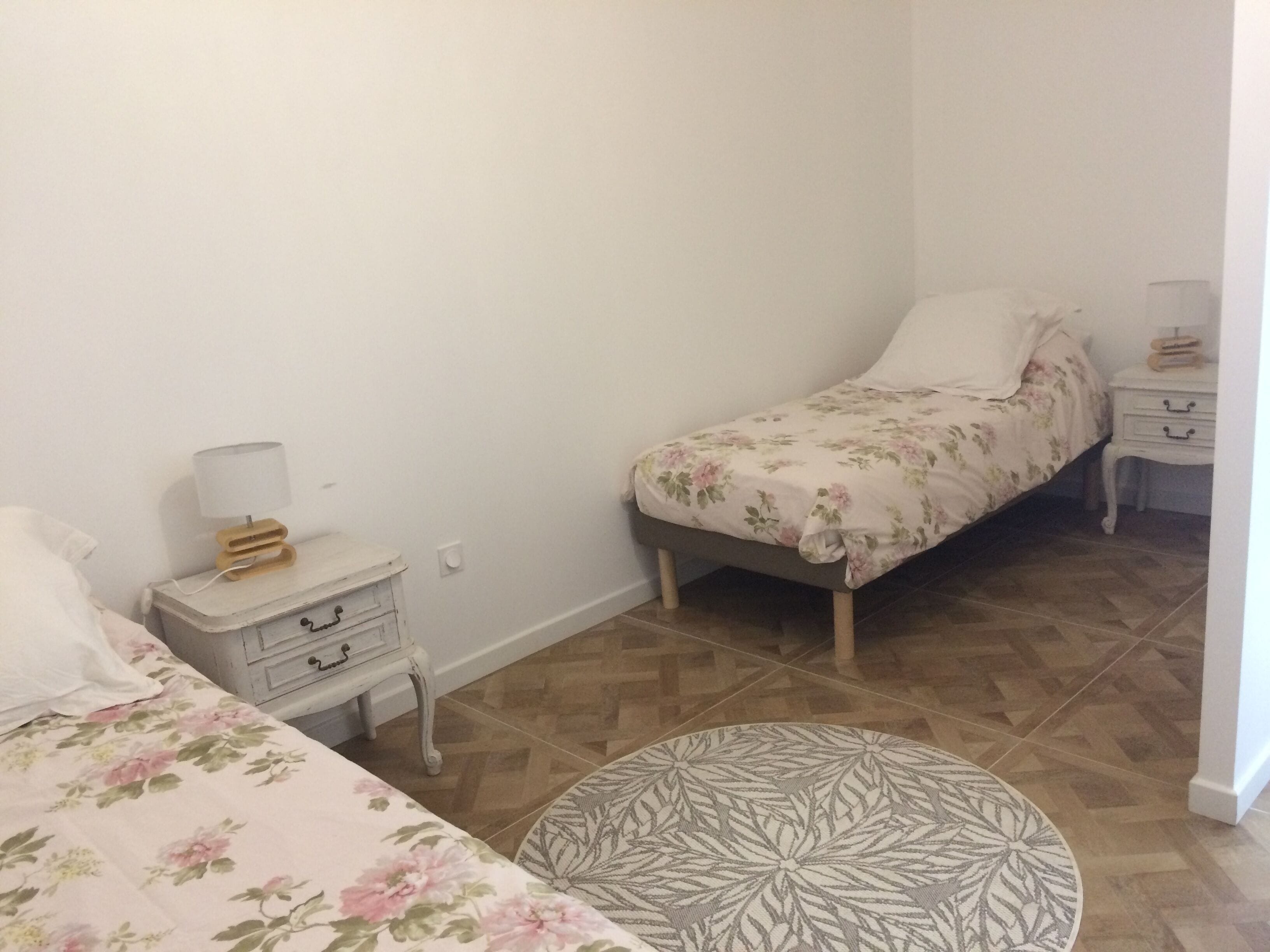 A bedroom with a bed, a nightstand, a dresser, and a round table.
