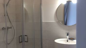 Comfort tweepersoonskamer | Badkamer | Een douche, gratis toiletartikelen, een haardroger, handdoeken