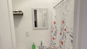 Ein kleines Badezimmer mit Toilette, Waschbecken und Duschvorhang.