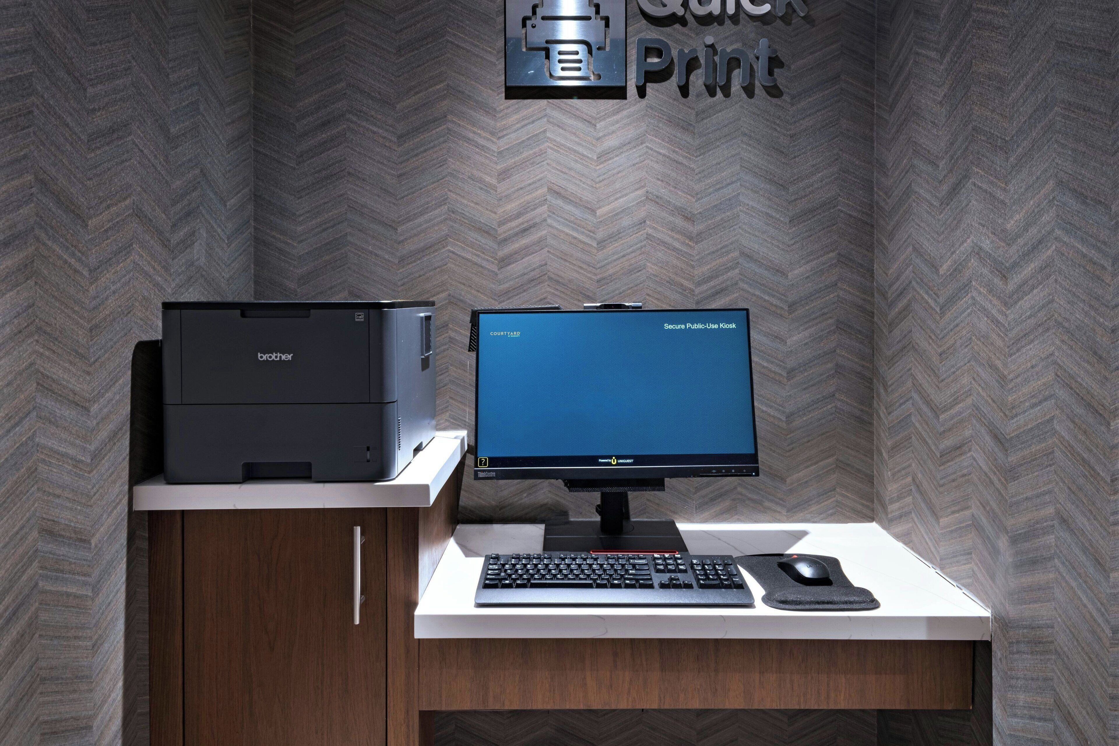 A Brother printer and a Brother monitor on a desk with a keyboard and mouse.