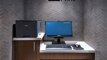A Brother printer and a Brother monitor on a desk with a keyboard and mouse.