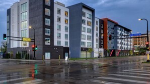 Een meerhoog gebouw met een modern architectonisch ontwerp, met grote ramen en een combinatie van donkere en lichte geveldelen.