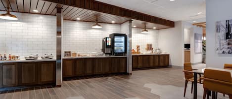 A modern kitchen with white subway tiles, wooden cabinets, and a central island.