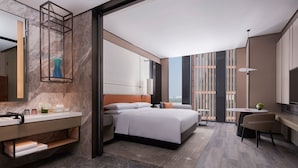 A modern hotel room with a large bed, a desk, a chair, a bathroom with a vanity, and a large window offering a city view. - Tianjin Marriott Hotel National Convention And Exhibition Center (Tianjin)