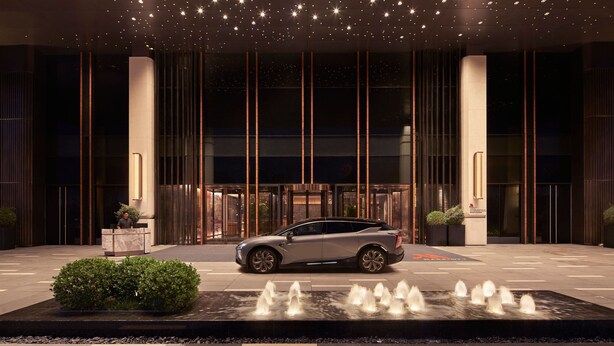 A modern building entrance with a car parked in front, a reception desk, and a water feature. - Tianjin Marriott Hotel National Convention And Exhibition Center (Tianjin)