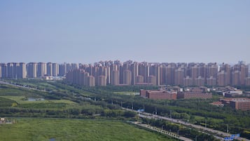 A high-rise residential area with dense apartment buildings, a highway, and green spaces.
