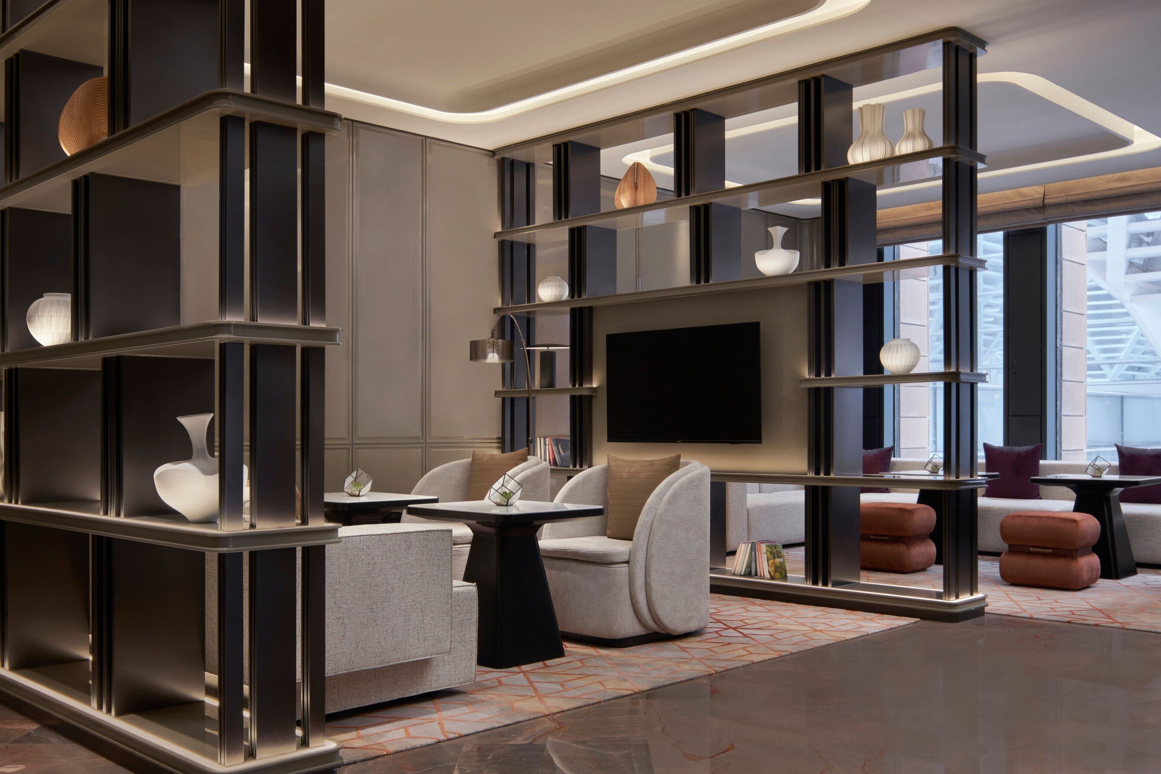 A modern interior with a large flat-screen TV, built-in shelving, and comfortable seating areas.