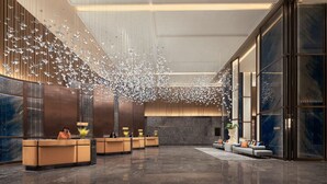 A modern lobby with a reception desk, seating area, and decorative ceiling elements. - Tianjin Marriott Hotel National Convention And Exhibition Center (Tianjin)