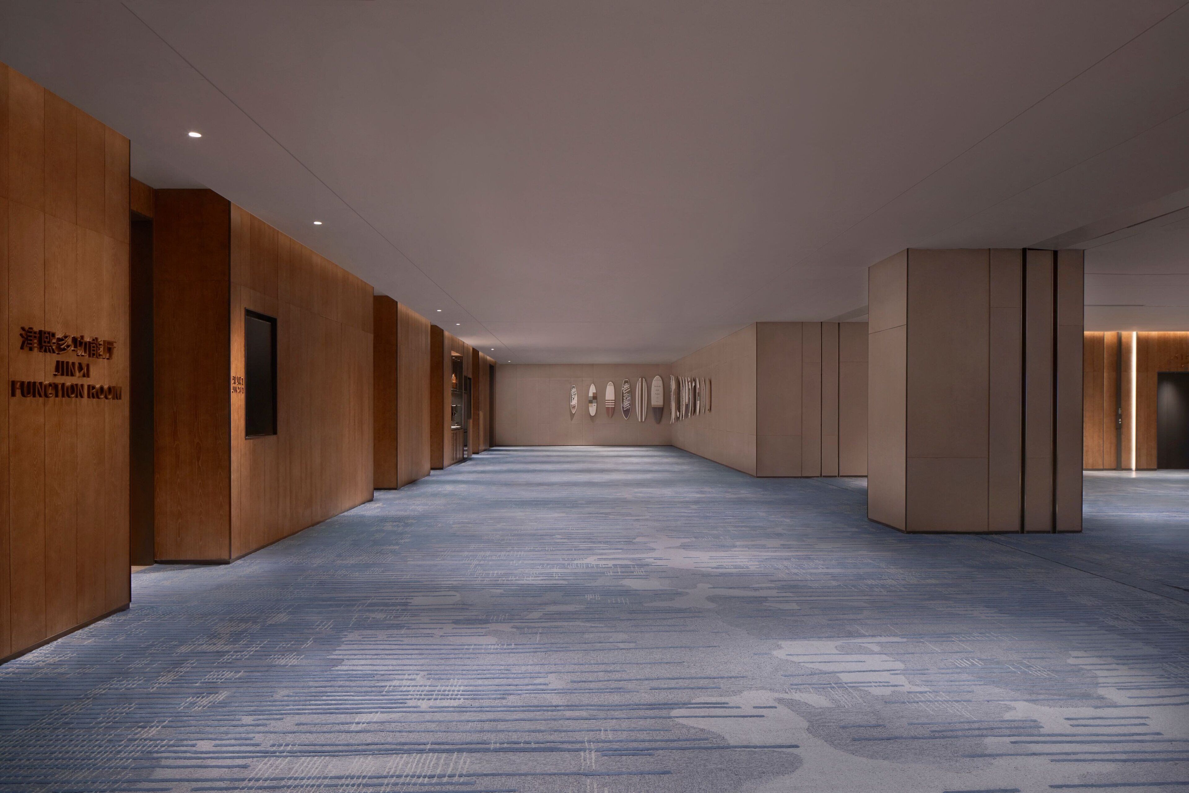 A modern hallway with wooden paneling and a patterned carpet.