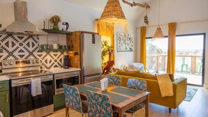 Une cuisine moderne avec un coin repas, un canapé et un balcon offrant une vue agréable.