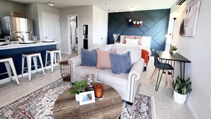 Un appartement moderne comprenant un salon, une cuisine et une chambre.