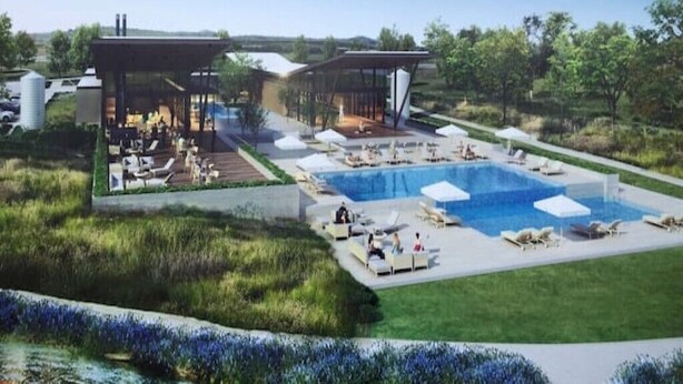 Un complexe hôtelier moderne doté d’une grande piscine, d  ’espaces extérieurs aménagés et d’un salon couvert.