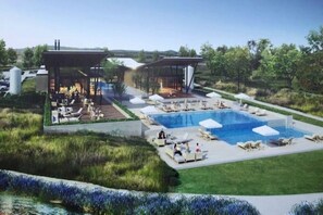 Ein modernes Resort mit großem Pool, Außenbereichen zum Sitzen und einer überdachten Lounge.