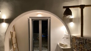A bathroom with a stone sink, a wooden ladder, and a glass door leading to a dark interior. - Beachhouse Omega Naxos - luxury holiday house - private pool & stunning sea view (Naxos)
