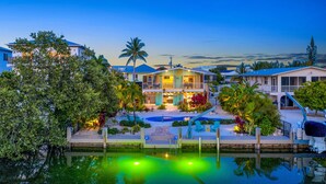A waterfront property with a swimming pool, multiple buildings, and lush landscaping. - Private pool home with dockage 3/2 near Sombrero (Marathon)