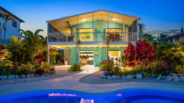 A two-story house with a swimming pool in the foreground. - Private pool home with dockage 3/2 near Sombrero (Marathon)