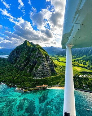 A mountainous landscape with a clear sky and turquoise waters.