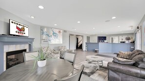 A modern hotel lobby with a fireplace, a dining area with a round table, patterned sofas, and a reception desk. - Schmidt's Creek Hotel (Osage Beach)