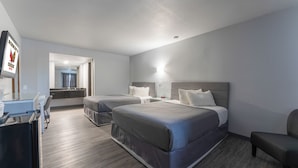 A hotel room with two beds, a desk, a mirror, and a television. - Schmidt's Creek Hotel (Osage Beach)
