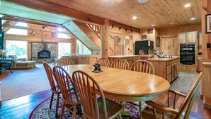 A cozy cabin interior with a dining area, kitchen, and living space.