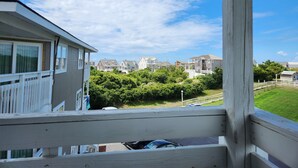 Ett bostadsområde med hus, en träterrass och en klar himmel.