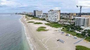 Une zone côtière avec une plage, des bâtiments et une grue de construction.