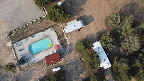 An aerial view of a property with a swimming pool, a red-roofed building, and a white RV. - Hacienda Roja - The Sage #6 at Wind Walker Homestead (Spring City)