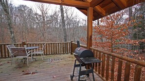 A wooden deck with a barbecue grill, a table, and chairs. - Grant's Escape - Couples Cabin in Hocking Hills (Logan)