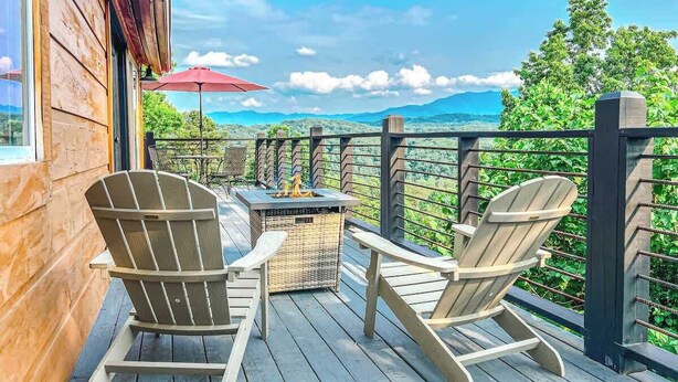 A wooden deck with Adirondack chairs, a fire pit, and a red umbrella. - Summer Deals/Amazing Views/Dollywood/Pet Friendly (Sevierville)