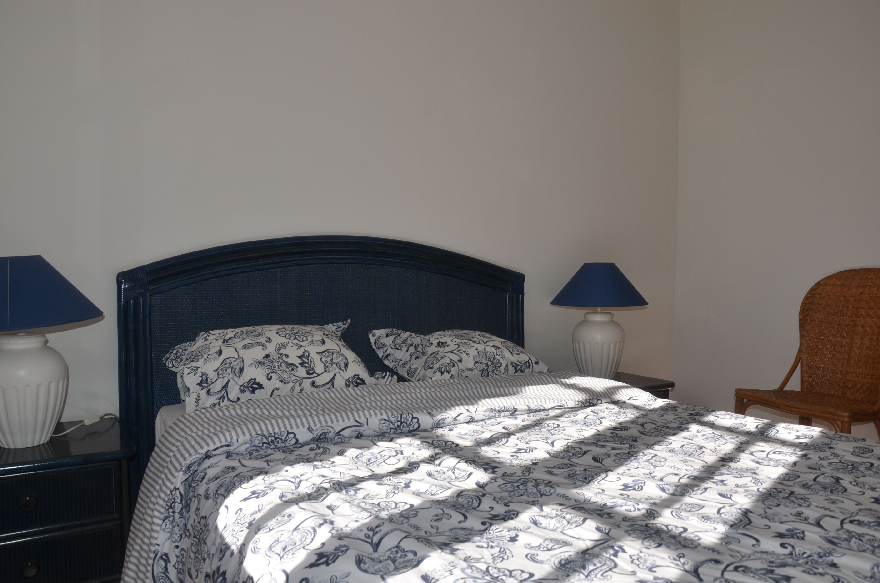 Ein Schlafzimmer mit einem Bett, zwei Nachttischen und einem Sessel.
