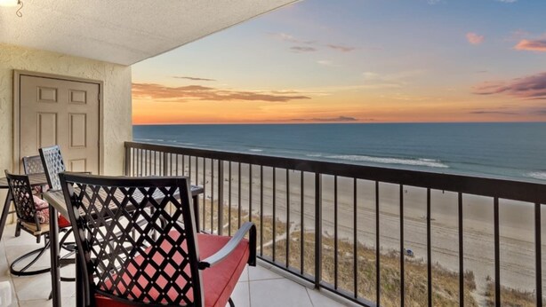 Ein Balkon mit Blick auf das Meer bei Sonnenuntergang.