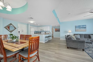 A modern living space with a dining area, kitchen, and a sofa in the living room.