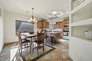 Une cuisine moderne avec des meubles en bois, un îlot central et un coin repas avec des chaises.