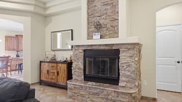 A stone fireplace with a Wi-Fi sign, a wooden cabinet, and a white door in a living room.