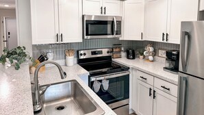A modern kitchen with white cabinets, stainless steel appliances, a granite countertop, and a built-in oven. - 5 min walk to village and slopes! Peaceful 3 BR 2 Bath retreat (Snowshoe)