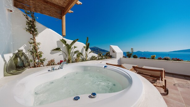 Un jacuzzi con vista despejada al mar y montañas al fondo.