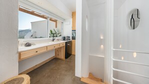 Una cocina moderna con un ventanal grande, armarios de madera y un lavavajillas.