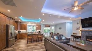 A modern kitchen with wooden cabinets, a central island, and a dining area with a sofa and coffee table. - 3 BR/3BA vacation home- minutes from the beach! (Pacific City)
