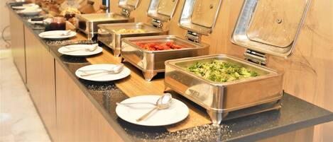 Una mesa de buffet con varios recipientes y utensilios para servir comida.